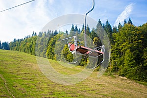 Emtpy chairlift in ski resort. Mountains and hills with in Summer with green trees