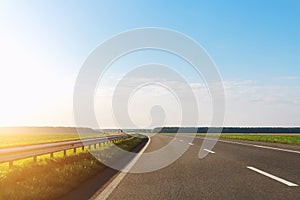 Emtpy view suburaban highway car road with motion blurred fast speed driving against blue sky on background at warm