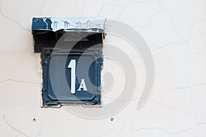 enameled house number one. White lettering on a black background