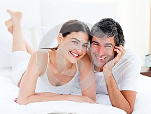 Enamored couple embracing lying on their bed