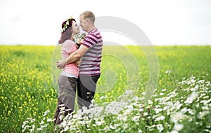 Enamored guy and girl in a green park with white daisies