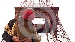 Enamored man passionately kissing beloved woman on romantic date in Paris