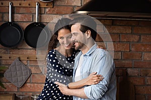 Enamored young couple have date cuddle at cozy wooden kitchen