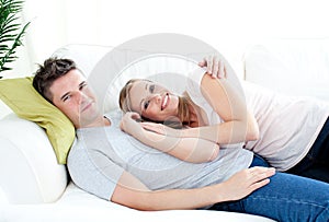 Enamored young couple lyingo together on the sofa