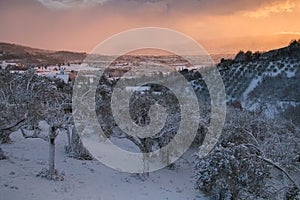 Enchanted atmosphere at winter sunset over Foligno with snow
