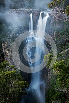 Enchanting Carrington Falls with wind blowing spray off waterfall