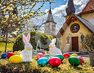 Enchanting Easter Scene: Bunnies, Eggs, and Gardens in the Farmer\'s Courtyard with a Church in the Background