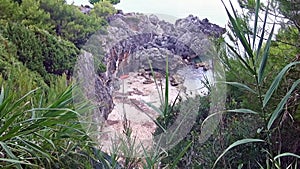 Enchanting sandy cove among vegetation and rocks.