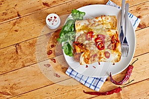 Enchiladas dish with red hot chili with sour cream