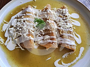 Enchiladas is Mexican cuisine made with rolled or folded corn tortillas and bathed in some spicy sauce with cream and cheese