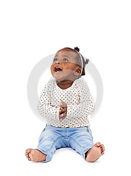 Encore. Studio shot of a happy baby girl sitting against a white background.