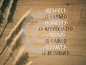 Encouragement quote of respect is earned honesty is appreciated trust is gained loyalty is returned. Written on wooden surface. photo