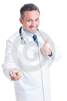 Encouraging doctor or medic offering hand full of various pills