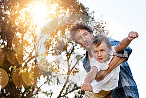 Encouraging him to live with courage and conviction. Portrait of a happy father playfully carrying his son during a fun