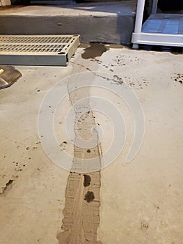 Initial seepage of floodwaters encroach through sealed crack in basement floor