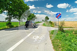 End of the cycle path signs and car on the asphalt road