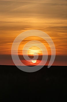 The end of the day just before the sunsets on the horizon with an amazing orange glow in riemst near Maastricht