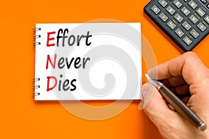 END effort never dies symbol. Concept words END effort never dies on beautiful white note. Beautiful orange background.