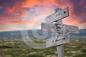 end limit boundary text engraved in wooden signpost outdoors in nature during sunset