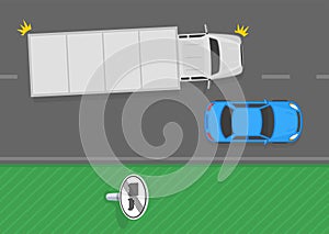 End of no overtaking by heavy goods vehicles sign area. Top view of a truck passing car on road.