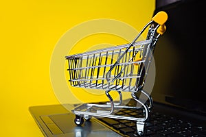 End of online sales. Online shopping, shopping cart on laptop keyboard.