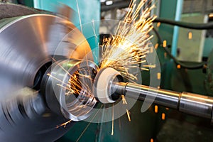 End processing of a metal surface with an abrasive stone on a circular grinding machine, sparks fly in different directions