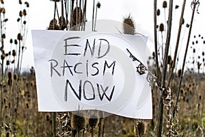 End Racism Now- message written on a paper. Concept- racism