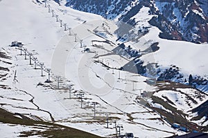 End of season, empty ski resort slope with four chairlifts, view above. Winter sports activities. Recreation place