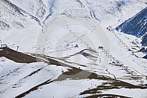 End of season, empty ski resort slope with four chairlifts, view above. Winter sports activities. Recreation place