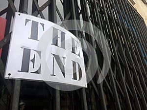 The End sign hanging in front of a closed store