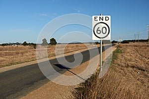 End of speed restriction road sign on a narrow Australian country road signifying an end to a 60 kilometre per hour safety speed l