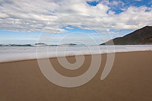 End of wave in the sand, with white foam