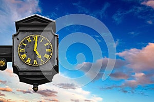 End of the work day. Old street clock showing 5 o\'clock with colorful sky in the background