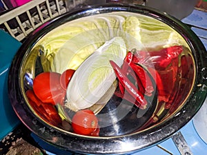 an endive, chili and tomato in stailess bowl photo