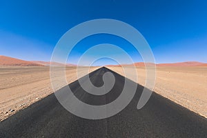 Endless desert road with blue sky. Copy space.