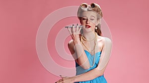 Endless emotional talk. Young beautiful girl with stylish hairstyle talking on smartphone over pink background. Pin-up