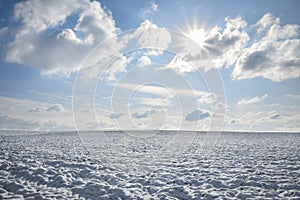 Endless field of snow and sunny sky