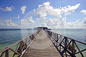 Endless jetty to the horizon; view to a turquoise sea and blue s