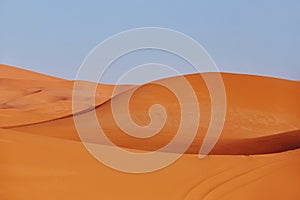 Endless Sands of the Sahara desert, the hot scorching sun shines on the sand dunes. Morocco Merzouga