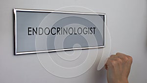 Endocrinologist office door, patient hand knocking closeup, thyroid disease