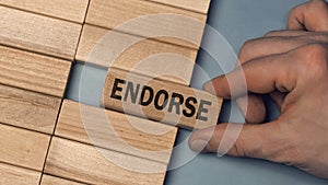 ENDORSE word concept. Close-up wooden piece blocks on the table