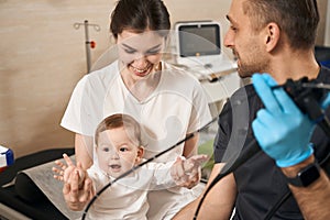 Endoscopist preparing child for endoscopy procedure under parental supervision