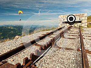 Endpoint of a rack railway on the top of a mountain with a paraglider in the background