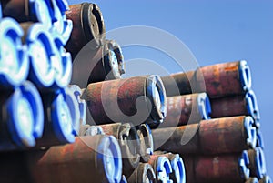 Ends of a stack of pipes covered with blue caps.