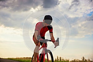 Endurance and motivation. Man, triathlete training, riding bicycle outdoors, preparing for marathon