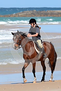 Endurance rider with horse on beach photo