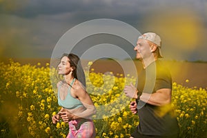 Endurance runners on a dirt track in a canola field, training