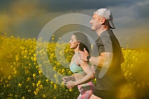 Endurance runners on a dirt track in a canola field, training