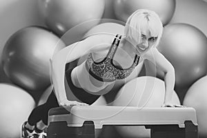 Endurance, strength and fitness concept. Girl in sportswear training on step platform in gym.