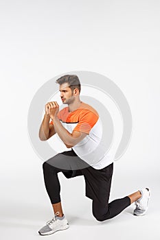 Endurance, workout and fitness concept. Motivated, serious-looking sportsman in activewear, bend on knee, create tension